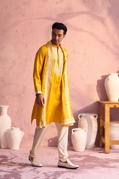 Shrestha by Vastramay - Men's Yellow Silk Kurta Pyjama Set Luxuriate in this elegant yellow silk kurta pyjama set featuring intricate machine embroidery. Perfect for festive occasions or special events. Key Features Yellow silk kurta with machine embroidery on neckline Mandarin collar, long sleeves, side slits, and pockets Cream colored pyjama with elasticated waistband Yellow embroidered silk dupatta Specifications Kurta Length: Knee Length Material & Care Top Fabric: Silk Blend Bottom: Cream colored pyjama fabric (material not specified on source website) Dupatta: Silk Dry Clean Only Legal Disclaimer: The product is guaranteed to be 100% genuine. Product images are for illustrative purposes only. Images/packaging/ labels may vary from time to time due to changes made by the manufacturer' Kurta Pyjama, Silk Kurta, Yellow Silk, Dupatta Set, Dress Inspo, Silk Dupatta, Sleeveless Jacket, Fabric Silk, Pyjama Set