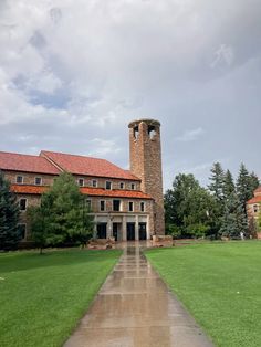 a large building with a clock tower in the middle of it's front yard