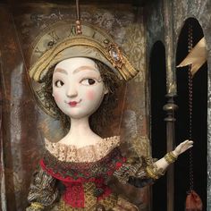 a doll is dressed in an old fashion dress and holding her hand out to the side