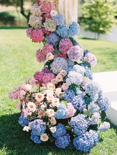 a bunch of flowers that are sitting in the grass on some grass and one is hanging from a pole