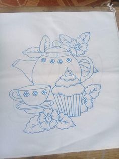 a tea pot with cupcakes and flowers on it is drawn on a piece of paper