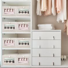 an organized closet with drawers and clothes hanging on the wall next to a white dresser