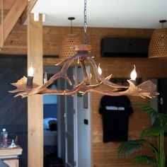 a wooden chandelier with antlers hanging from it's sides in a living room