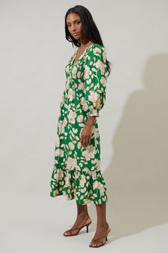 A season favorite list has to include the Lucena Floral Lemy Poplin Midi Dress. It features long sleeves, smocked bodice, and a v-neckline. The bottom has a ruffle hem tier. Wear it with matching ivory heels to create a full look. - Smocked- Deep V-neck- Floral- Lined- Color: Green MultiSize + Fit - Model is 5'10" and wearing size XS- Measurements taken from size S - Chest: 15 1/4"- Length: 49 3/4" Fabric Self: 100% Cotton, Lining: 97% Polyester 3% Spandex Style Number STD14589P Spring V-neck Dress With Smocked Cuffs, Spring V-neck Smocked Dress For Daywear, Green Smocked Summer Dress With Gathered Sleeves, Green Smocked Dress With Gathered Sleeves For Summer, Green Ruched Midi Dress For Fall, Green Dresses With Elastic Sleeves For Fall, Green Fall Dress With Elastic Sleeves, Green Dress With Elastic Sleeves For Fall, V-neck Midi Dress With Smocked Bodice For Garden Party