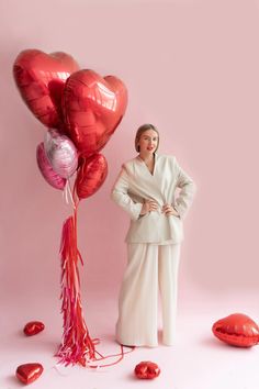 a woman standing in front of balloons and streamers with her hands on her hips