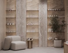 a white chair sitting in front of a wall filled with bottles and vases next to a table