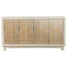 an art deco sideboard with four doors and geometric designs on the front, in white wood