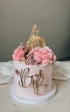 a cake with pink flowers and a gold crown on top that says b is for b is for b