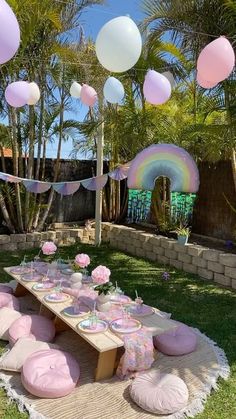 a picnic table with pink and white balloons