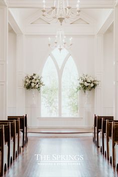 an empty church with white flowers and chandelier