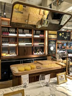 an empty restaurant with wine bottles and glasses on the bar counter, along with other items