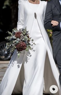 the bride and groom are walking down the street