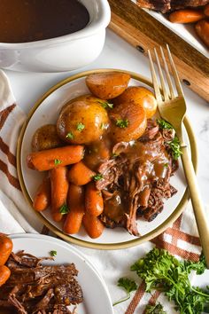 a white plate topped with roast, potatoes and carrots next to a bowl of gravy