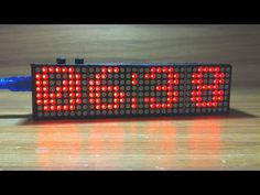 an electronic clock with the word time displayed on it's display screen, sitting on a wooden surface