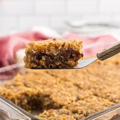 a close up of a spoon with some food on it and a piece of cake in the background