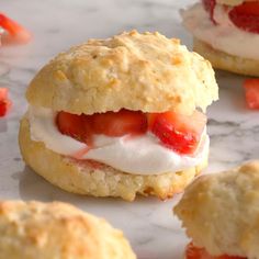 strawberry shortcakes with whipped cream and strawberries on them are sitting on a marble surface