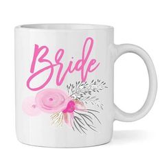 a white coffee mug with pink flowers and the word bride on it's side