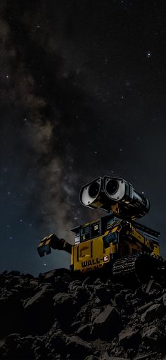 a yellow truck is parked on the side of a hill with stars in the sky