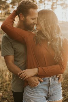 a man and woman embracing each other in an open field