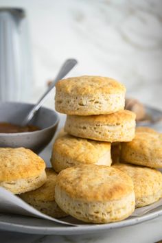 biscuits stacked on top of each other with a bowl of dipping sauce in the background