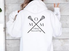 Stay warm and stylish on game day with our custom Lacrosse Mom Hoodie, the perfect gift for proud lax mamas! 🥍 This cozy sweatshirt not only showcases your love for the sport but can also be personalized with your kids' names for a special touch. 💕 Whether you're cheering from the sidelines or running errands, our Lacrosse Mom Sweater with a unique sleeve design is a must-have for any lacrosse team mom. Treat yourself or surprise a fellow lax mama with this custom lacrosse gift, ideal for Moth Customizable Long Sleeve Sports Hoodie, Customizable Sports Hoodie, Customizable Sporty Hoodie For Sports, White Hooded Hoodie For Team Events, White Long Sleeve Hoodie For Team Events, Mom With Kids, Team Mom Gifts, Lacrosse Gifts, Lacrosse Mom