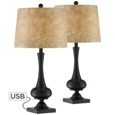 two black lamps with a beige shade on each lamp and the light is plugged in