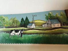 a painting of a cow grazing in a field next to a barn and windmill on the wall