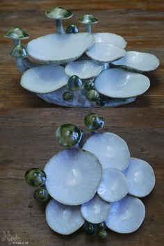 several white dishes stacked on top of each other with small green balls in the middle