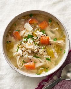 a bowl of chicken noodle soup with carrots, celery and parsley