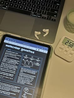 an electronic device sitting on top of a desk next to a laptop computer and calculator