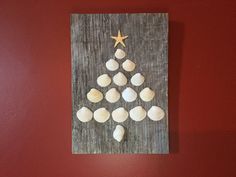 a christmas tree made out of seashells on a wooden board