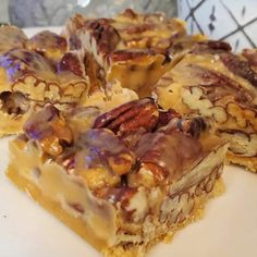 some kind of dessert on a plate with pecans and nuts in the top layer