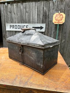 an old metal box sitting on top of a wooden table