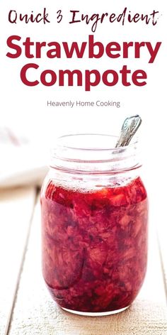 a jar filled with strawberry compote sitting on top of a wooden table