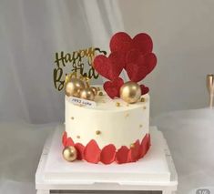 a white cake with red and gold decorations