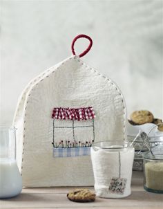 a white bag sitting on top of a wooden table next to cookies and other items