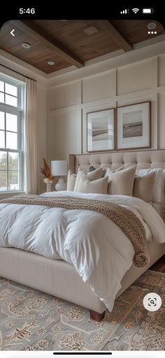 a large white bed sitting in a bedroom next to a window