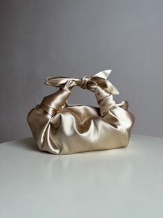 Champagne satin bag with knots. Stylish small handmade bag that is suitable for any event. Bag with bows is soft, closes with a magnetic button. This knotted bag is made in a vintage style based on the Japanese technique of tying a silk women's scarf into a handbag. Elegant woman light gold bag is very roomy - fits a phone, wallet, keys, makeup. Perfect wedding purse. The handbag can be sewn from satin or velvet. I have a huge selection of colors, more than indicated in the listing. Please write Satin Purses, Origami Bag, Big Handbags, Knot Bag, Woman Handbag, Japanese Bag, Colors Wedding, Wedding Purse, Satin Bags