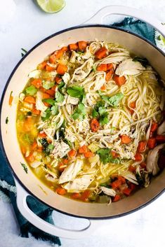 a pot filled with chicken noodle soup and garnished with cilantro