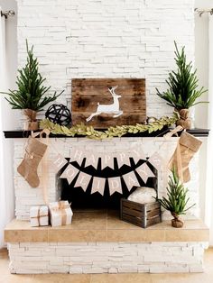 a fireplace decorated for christmas with burlocks, stockings and deer decorations on the mantel