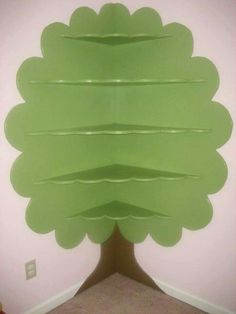 a large green tree made out of plastic sheeting on the side of a wall