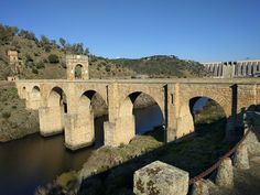 an old stone bridge spanning the width of a river