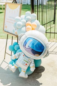 an inflatable astronaut doll sitting next to a welcome sign