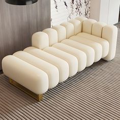 a white couch sitting on top of a hard wood floor next to a black lamp