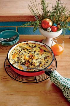 a casserole dish on a wire rack next to a bowl of oranges