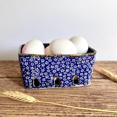 three eggs are in a blue and white container