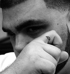 a man holding his hand to his face with the word love tattooed on it's forehead