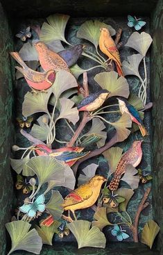 a box that has some birds on top of leaves and flowers in the bottom half