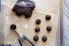 chocolate cookies and cookie cutters sitting on top of a piece of parchmented paper