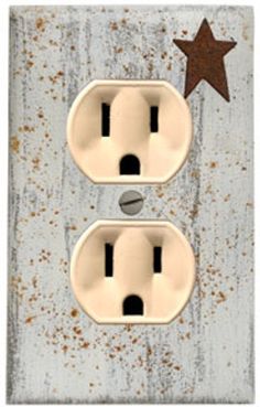 two white electrical outlets with one brown star on the left and one black dot on the right